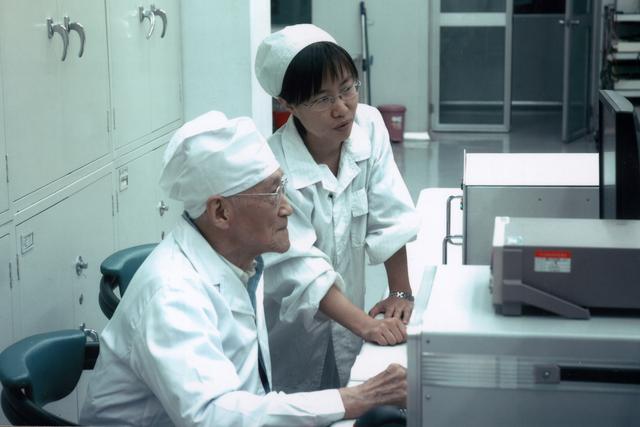 陆元九院士在航天时代电子公司激光陀螺实验室与同事探讨问题（2006年摄）。新华社发（中国航天科技集团供图）.jpg