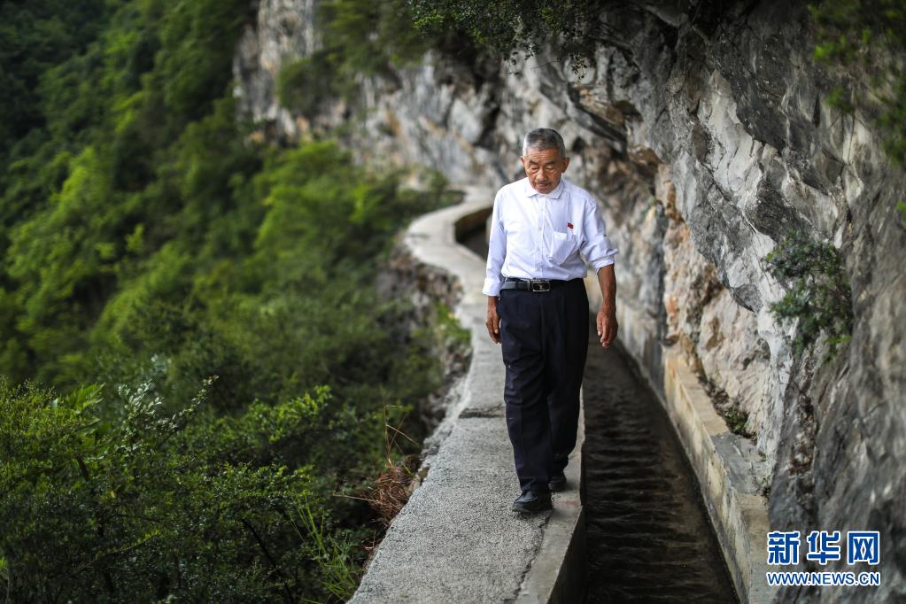 黄大发沿着修建在绝壁上的“大发渠”巡查（2018年8月11日摄）。新华社记者 刘续 摄.jpg