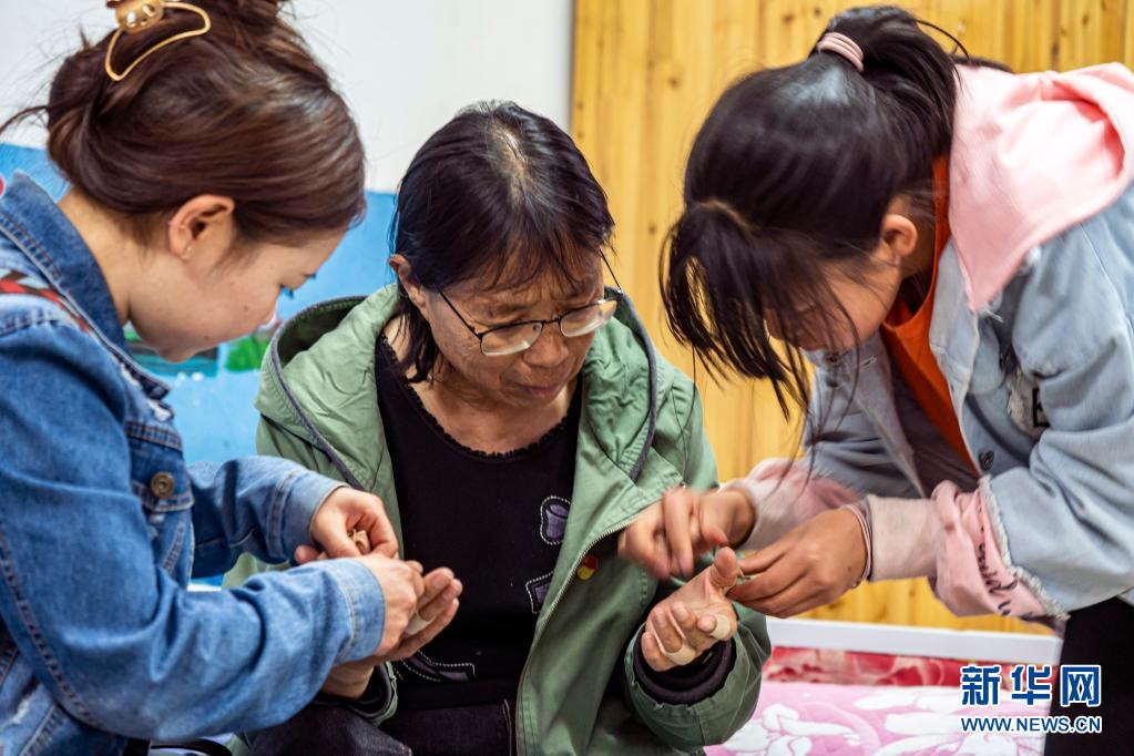 每天回到福利院，孩子们都会帮张桂梅撕掉贴了一天的止痛胶带（3月23日摄）。新华社记者 江文耀 摄.jpg